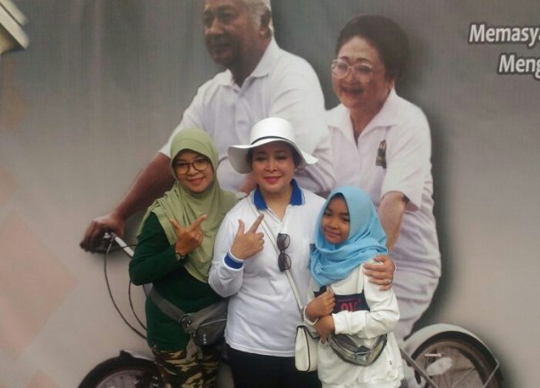 Warga antusias berfoto di poster besar Presiden Soeharto dan Ibu Tien bersepeda/ist Warga antusias berfoto di poster besar Presiden Soeharto dan Ibu Tien bersepeda/ist