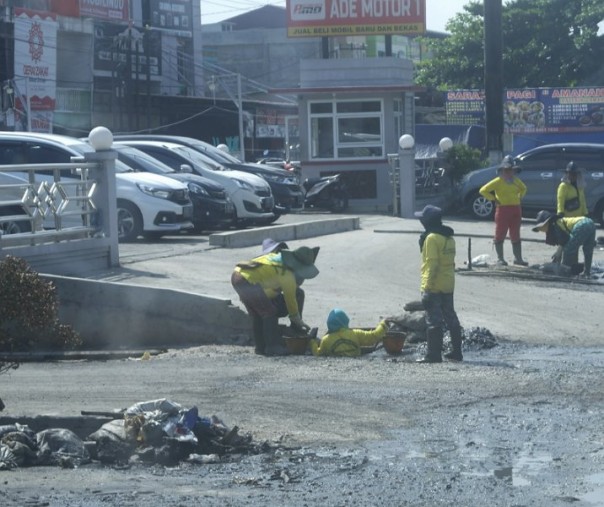 Pasukan kuning Dinas PUPR Pekanbaru saat membersihkan drainase Jalan Soekarno-Hatta dari tumpukan sampah. Foto: Surya/Riau1. 