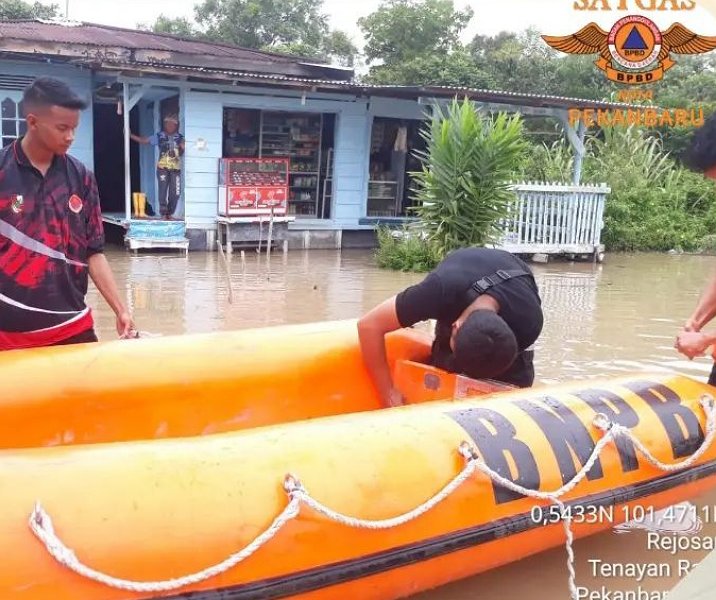 Tim BPBD Pekanbaru menurunkan perahu karet guna mengevakuasi warga di Kelurahan Rejosari, Kamis (22/12/2022). Foto: BPBD.