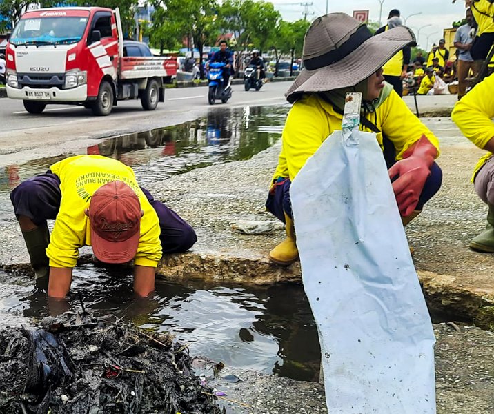 Pasukan kuning Dinas PUPR Pekanbaru harus membongkar drainase agar bisa membersihkan sampah dan sedimen di Jalan Soebrantas, Senin (4/12/2023). Foto: Istimewa.