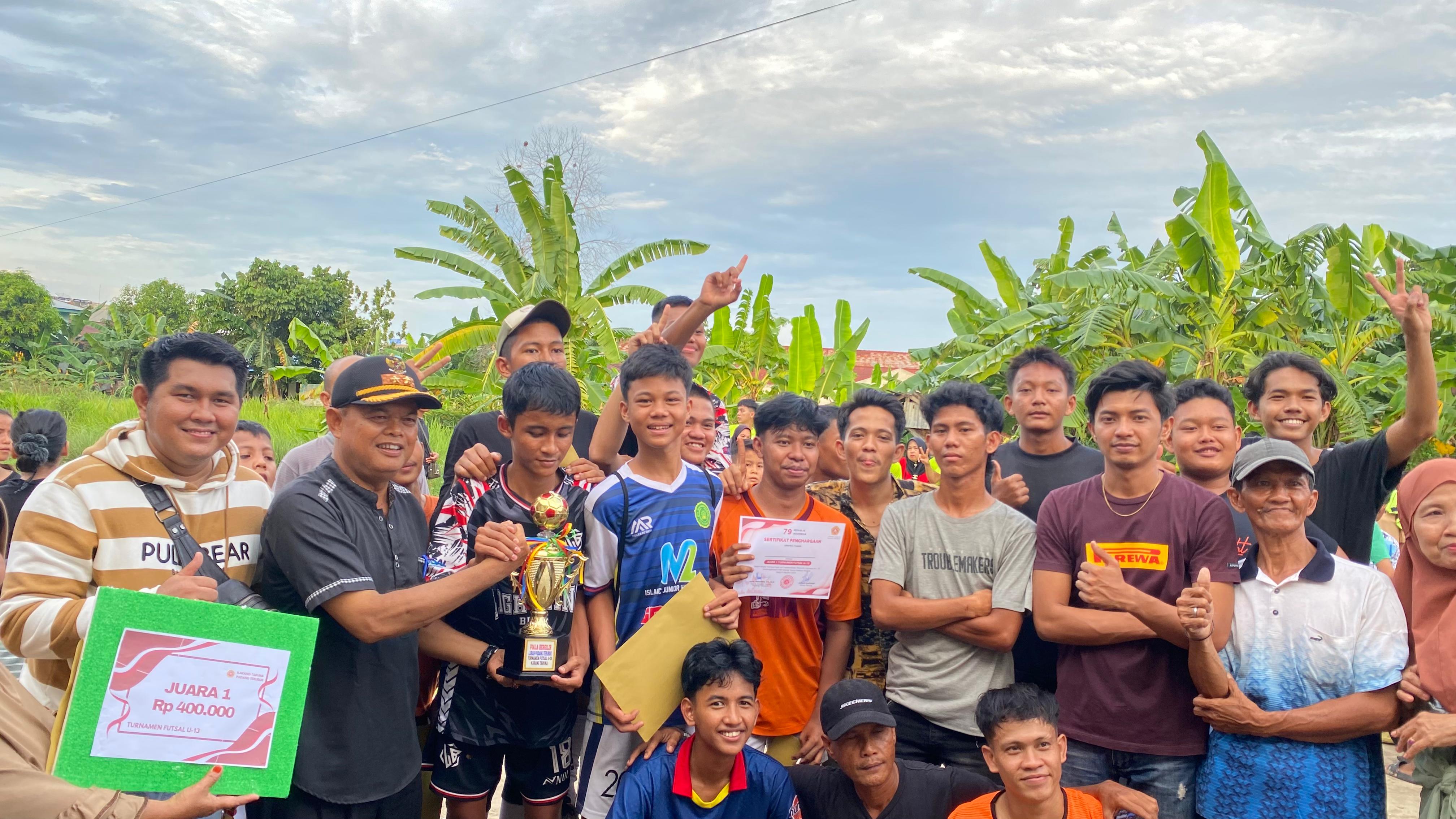 Lurah Padang Terubuk Syafrianto bersama Ketua Karang Taruna Padang Terubuk, Hafid Muhaimin menyerahkan hadiah lomba futsal U-13