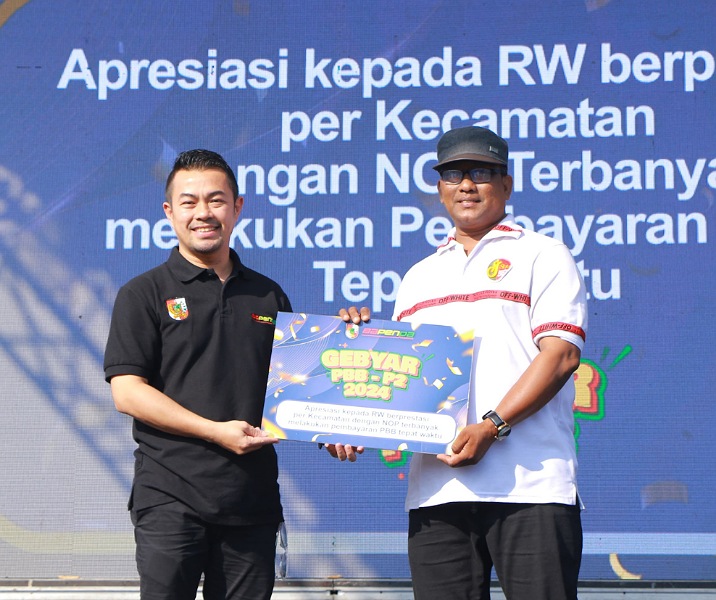 Pj Wali Kota Pekanbaru Risnandar Mahiwa menyerahkan apresiasi kepada perwakilan para ketua RW di acara Gebyar PBB-P2, Minggu (27/10/2024). Foto: Istimewa.