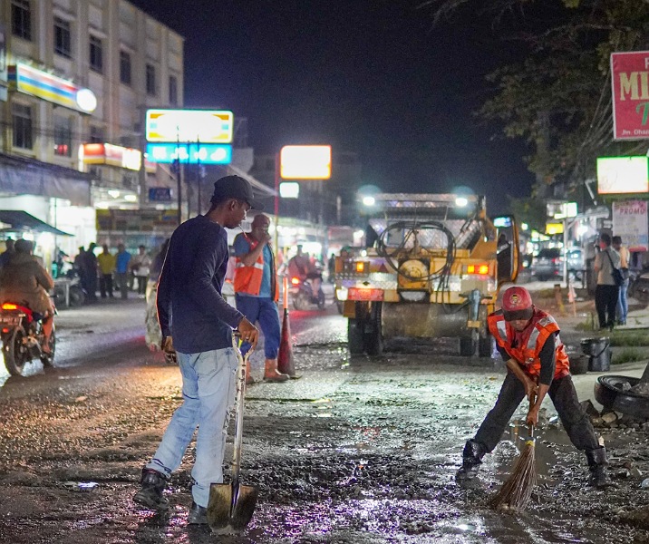 Pekerja Dinas PUPR Pekanbaru saat memulai proses penambalan jalan berlubamg di Jalan Dharma Bakti Sigunggung, Sabtu (22/2/2025) malam. Foto: Istimewa.