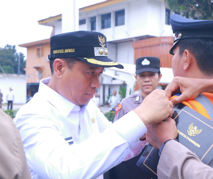 Wakil Wali Kota Pekanbaru Markarius Anwar saat memasang pin kepada perwakilan anggota Dishub tanda dimulainya Operasi Ketupat, Rabu (19/3/2025). Foto: Istimewa.