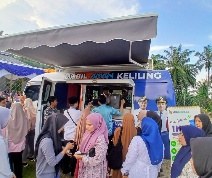 Warga sedang mengurus dokumen kependudukan di mobil cetak KTP keliling. Foto: Surya/Riau1.