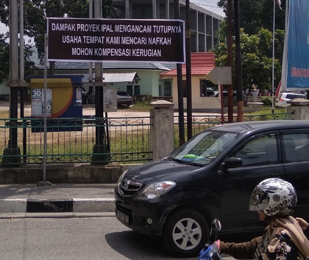 Spanduk protes dan permintaan kompensasi akibat proyek Kementerian PUPR di Kecamatan Sukajadi, Pekanbaru, Senin (5/8/2019). Foto: Surya/Riau1.