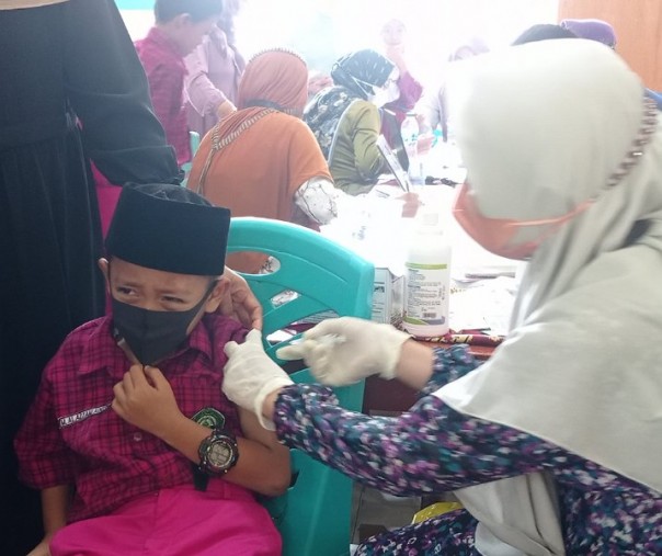 Murid Madrasah Ibtidaiyah Al Ikhwan ketakukan saat disuntik vaksin, Jumat (28/1/2022). Foto: Surya/Riau1.