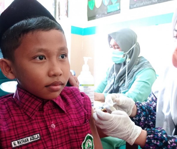 Murid MI Al Ikhwan Pekanbaru terlihat tenang saat disuntik vaksin, Jumat (28/1/2022). Foto: Surya/Riau1.