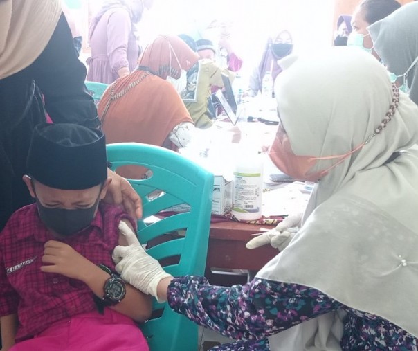 Seorang murid MI Al Ikhsan ketakutan saat melihat jarum suntik vaksin, Jumat (28/1/2022). Foto: Surya/Riau1.