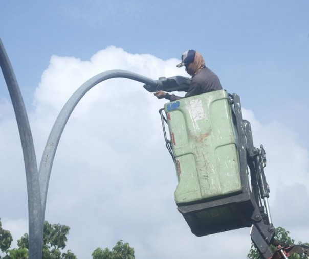 Pekerja dari Dishub Pekanbaru saat mengganti lampu jalan di Jalan Jenderal Sudirman. Foto: Surya/Riau1.