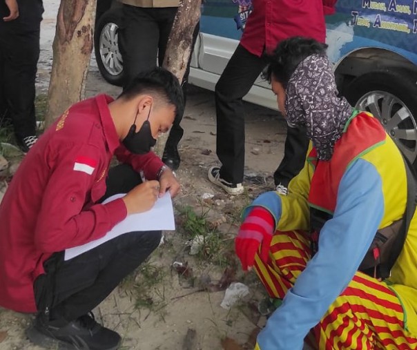 Petugas Dinsos Pekanbaru mendata identitas seorang badut jalanan. Foto: Istimewa. 